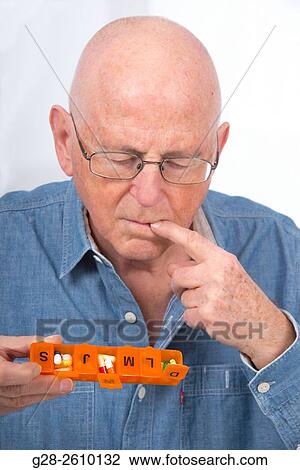 Senior man holding a weekly pill organiser View Large Photo Image Stock Image - Senior man holding a weekly pill organiser. Fotosearch