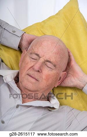 Senior man quietly having an afternoon nap at home on a sofa View Large Photo Image Stock Photo - Senior man quietly having an afternoon nap at home on a sofa. Fotosearch