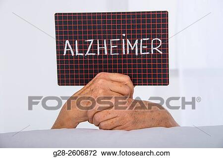 Senior Woman? s hands holding a black slate with Alzheimer written on it View Large Photo Image Stock Image - Senior Woman? s hands holding a black slate with Alzheimer written on it. Fotosearch