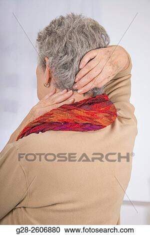 Senior woman with grey hair, seen from behind, suffering from a neck pain, trying to relieve pain by massaging her back View Large Photo Image Stock Image - Senior woman with grey hair, seen from behind, suffering from a neck pain, trying to relieve pain by massaging her back. Fotosearch