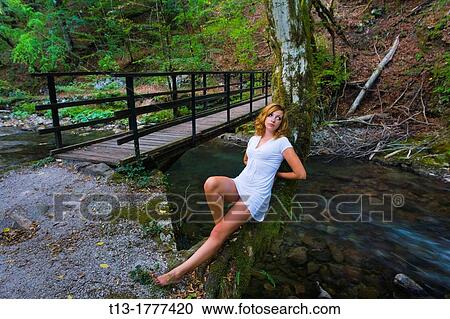 Sitting next to a footbridge young woman in a White dress View Large Photo Image Stock Image - Sitting next to a footbridge young woman in a White dress. Fotosearch
