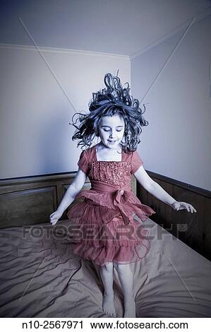 Stock Image - Six year old girl on her bed.. Fotosearch