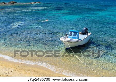 Small boat moored to a beach in Naxos, Cyclades, Greece. View Large Photo Image Stock Image - Small boat moored to a beach in Naxos, Cyclades, Greece.. Fotosearch