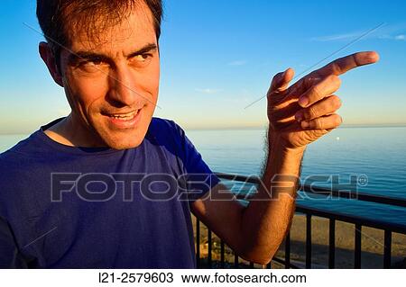 Smiling man pointing the finger in any direction. View Large Photo Image Stock Image - Smiling man pointing the finger in any direction.. Fotosearch