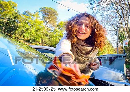 Smiling woman cleaning the front glass of her car outdoor. View Large Photo Image Stock Photography - Smiling woman cleaning the front glass of her car outdoor.. Fotosearch