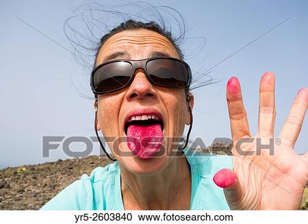 Stock Image - Spanish woman picking, peeling and eating prickly pear fruit from Cactus plant on Gran Canaria, Canary Islands, Spain.. Fotosearch