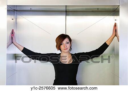 Stock Photography - Spreading hands in elevator beautiful teen girl. Fotosearch