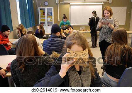 Stock Photo - STOCKHOLM, SWEDEN Class 8A at the Blommenbergsskolan school in Grndal gets a hands on demonstration of Google Glasses, a 3 D Virtual Reality (VR) headset made of cardboard and 3D glasses to view special photos on a mobile phone. The cardboard box is slott. Fotosearch