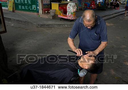 Stock Image - Street barbers at outskirt of Guangzhou, China.. Fotosearch