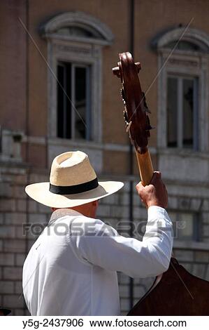 Street entertainer playing double bass musical instrument in piazza navona square in Rome, Italy View Large Photo Image Stock Photograph - Street entertainer playing double bass musical instrument in piazza navona square in Rome, Italy. Fotosearch
