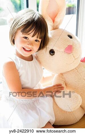 Stock Image - Sweet toddler girl with her Easter bunny.. Fotosearch