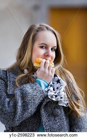 Stock Image - Teen girl eating donut. Fotosearch