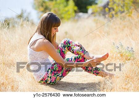 Teen-girl in colorful pants in nature brushing dirt from feet View Large Photo Image Stock Image - Teen-girl in colorful pants in nature brushing dirt from feet. Fotosearch