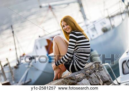 Teen girl posing tucked legs before yacht in marina View Large Photo Image Stock Photo - Teen girl posing tucked legs before yacht in marina. Fotosearch