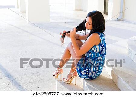 Stock Photo - Teen girl sitting and pulling-away hair. Fotosearch