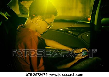 Teenage boy, manipulating a cell phone in a taxi. Barcelona, Catalonia, Spain View Large Photo Image Stock Photography - Teenage boy, manipulating a cell phone in a taxi. Barcelona, Catalonia, Spain. Fotosearch