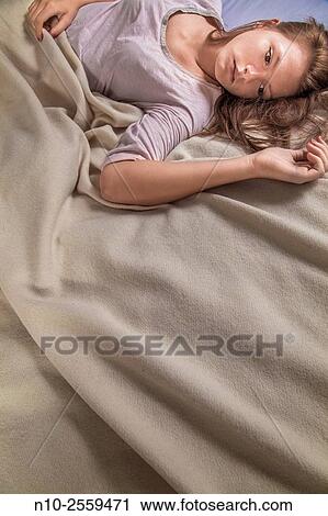 Stock Image - Teenage girl on her bed.. Fotosearch
