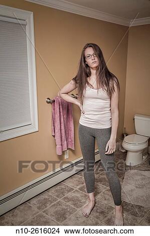 Teenage girl, wearing glasses, standing in the bathroom. View Large Photo Image Picture - Teenage girl, wearing glasses, standing in the bathroom.. Fotosearch