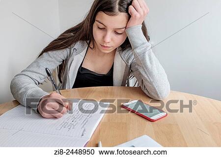 Teenage girl working on her homework, using her smart phone. View Large Photo Image Stock Image - Teenage girl working on her homework, using her smart phone.. Fotosearch