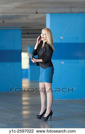Stock Image - Teenager blonde girl talking using cell-phone. Fotosearch