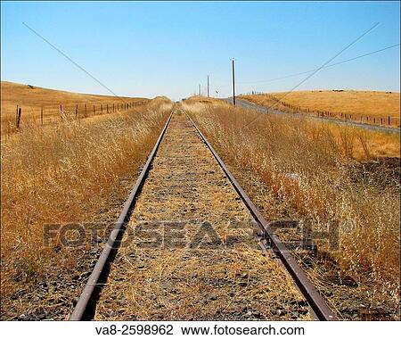 These endless railroad tracks march across golden hills located in Folsom, California. View Large Photo Image Stock Image - These endless railroad tracks march across golden hills located in Folsom, California.. Fotosearch