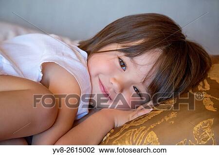 Three year old girl resting on the bed. View Large Photo Image Stock Image - Three year old girl resting on the bed.. Fotosearch