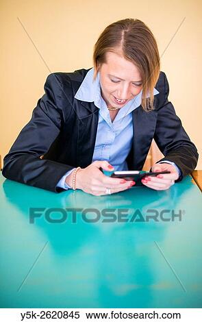 Tilburg, Netherlands. Attractive, blonde woman reading her e-mail messages using her smartphone. View Large Photo Image Stock Photography - Tilburg, Netherlands. Attractive, blonde woman reading her e-mail messages using her smartphone.. Fotosearch