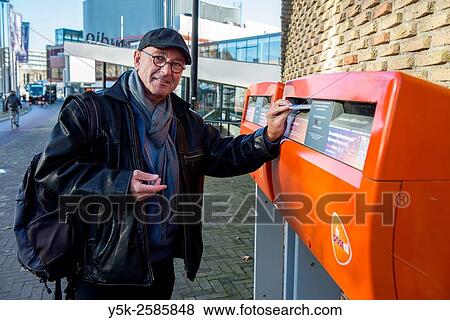 Tilburg, Netherlands. Man with cap and glasses posting an enveloppe in a Dutch mailbox. View Large Photo Image Stock Photo - Tilburg, Netherlands. Man with cap and glasses posting an enveloppe in a Dutch mailbox.. Fotosearch