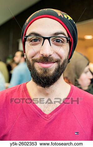 Tilburg, Netherlands. Portrait on location of a very happy Syrian refugee with glasses and hoody. View Large Photo Image Stock Image - Tilburg, Netherlands. Portrait on location of a very happy Syrian refugee with glasses and hoody.. Fotosearch
