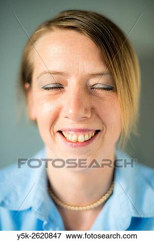 Tilburg, Netherlands. Studio portrait of an attractive, blonde woman, smiling with eyes shut. View Large Photo Image Stock Photo - Tilburg, Netherlands. Studio portrait of an attractive, blonde woman, smiling with eyes shut.. Fotosearch
