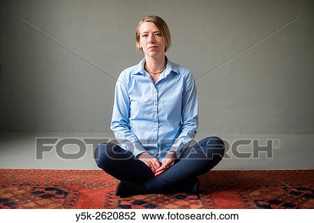 Tilburg, Netherlands. Studio shot of an attractive, blonde woman sitting on carpet. View Large Photo Image Stock Image - Tilburg, Netherlands. Studio shot of an attractive, blonde woman sitting on carpet.. Fotosearch