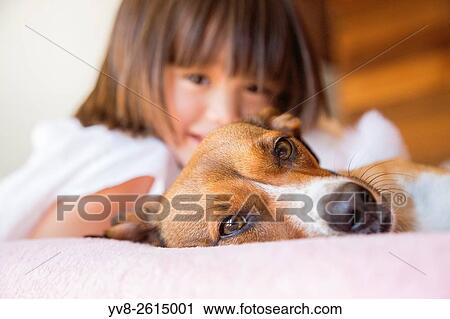 Toddler girl and her pet dog laying on the bed. View Large Photo Image Stock Image - Toddler girl and her pet dog laying on the bed.. Fotosearch