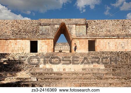 Stock Photo - Tourist at the entrance to the Quadrangle Of The Nuns in Uxmal ruins, Prehispanic Mayan city of Uxmal Archaeological Site, Yucatan Province, Mexico, Central America.. Fotosearch