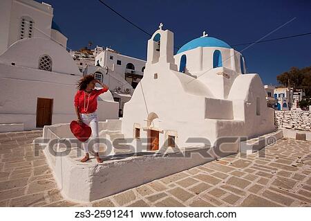 Stock Image - Tourist woman in front of the blue domed church in Chora, Ios, Cyclades Islands, Greek Islands, Greece, Europe.. Fotosearch
