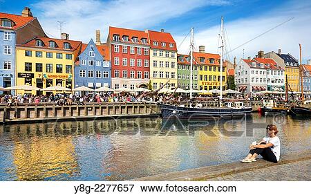 Stock Photo - Turists resting at Nyhavn Canal, Copenhagen, Denmark.. Fotosearch