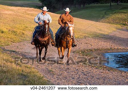 Two wranglers (cowboys) on horses, riding near a pond, California, USA View Large Photo Image Stock Photo - Two wranglers (cowboys) on horses, riding near a pond, California, USA. Fotosearch