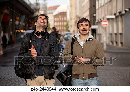 Two young people laughing in the street. View Large Photo Image Picture - Two young people laughing in the street.. Fotosearch