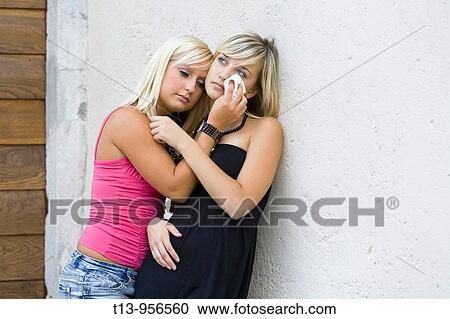 Stock Image - Two young women together crying. Fotosearch