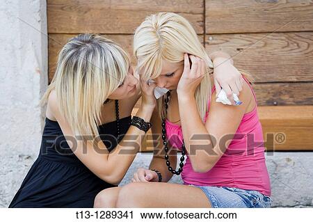 Stock Image - Two young women together one is crying. Fotosearch