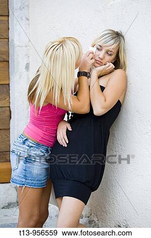 Stock Photo - Two young women together, one is crying. Fotosearch