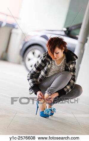 Stock Photo - Tying her Blue high-heeled shoe. Fotosearch