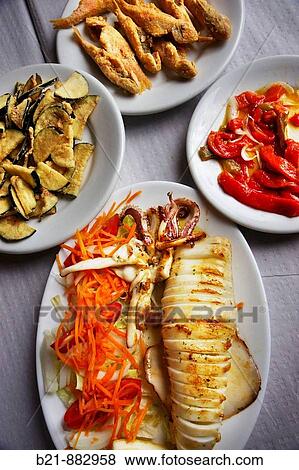 Typical food from Malaga at Restaurante Victoria on Palo beach: fried aubergines, fried red mullets, red peppers salad and grilled squid. Andalusia, Spain View Large Photo Image Stock Photo - Typical food from Malaga at Restaurante Victoria on Palo beach: fried aubergines, fried red mullets, red peppers salad and grilled squid. Andalusia, Spain. Fotosearch