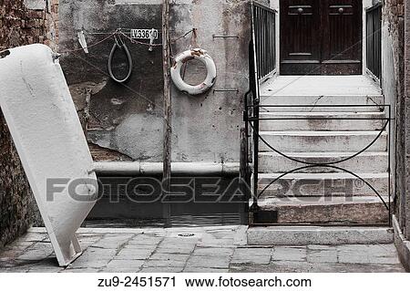 Stock Image - Various items by a small canal at the private entrance to a Venetian house, Venice, Veneto, Italy, Europe.. Fotosearch