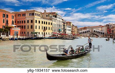 Venice - Grand Canal (Canal Grande), gondola with tourists on the canal, Rialto Bridge in the background, Venice, Italy. View Large Photo Image Stock Photo - Venice - Grand Canal (Canal Grande), gondola with tourists on the canal, Rialto Bridge in the background, Venice, Italy.. Fotosearch