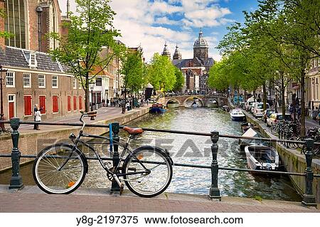 Stock Photography - View at bicycle, canal and St. Nicolas Church - Amsterdam, Holland Netherlands.. Fotosearch