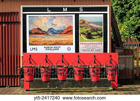Vintage LMS travel posters and GWR fire fighting buckets at Hampton Loade station, Severn Valley Railway, Shropshire, England, Europe. View Large Photo Image Stock Image - Vintage LMS travel posters and GWR fire fighting buckets at Hampton Loade station, Severn Valley Railway, Shropshire, England, Europe.. Fotosearch