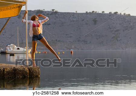 Stock Photo - Welcoming Summer teenager girl is balancing above water. Fotosearch