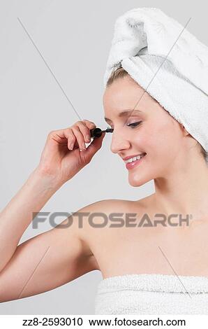 Woman applying mascara after shower with white towel on her head. View Large Photo Image Stock Image - Woman applying mascara after shower with white towel on her head.. Fotosearch