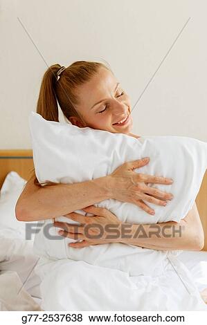 Woman hugging a pillow View Large Photo Image Stock Photo - Woman hugging a pillow. Fotosearch