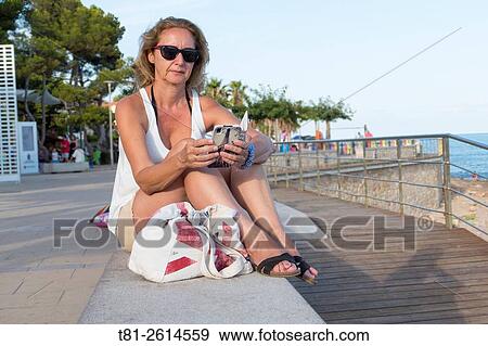 woman looking at cell phone on vacation. Alcocebre. Spain View Large Photo Image Stock Photo - woman looking at cell phone on vacation. Alcocebre. Spain. Fotosearch